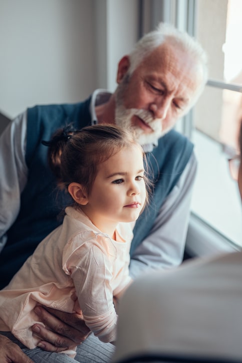 man sitting with his granddaughter by the window