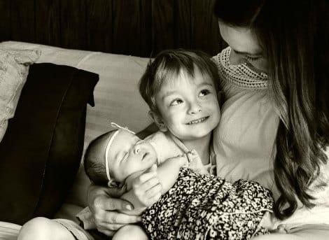 Adoptive mother holds her biological and adopted children