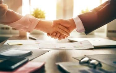 Man and woman are shaking hands in office. Collaborative teamwork.