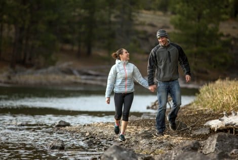 Young couple walk along a river while working on their Christian marriage