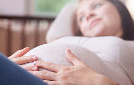 Pregnant teen with her hands on her belly