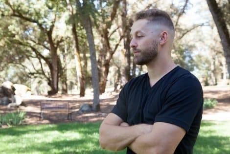 Man standing outside with his arms crossed as he thinks about adoption