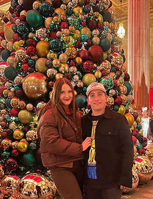 Wioleta and Matt pose by a large Christmas tree