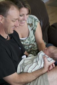 Christian adoptive parents Pete and Janna admire their adopted baby