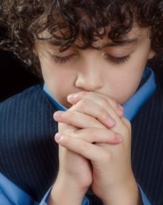 young boy saying his prayers