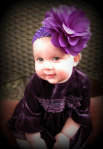baby with purple bow 
