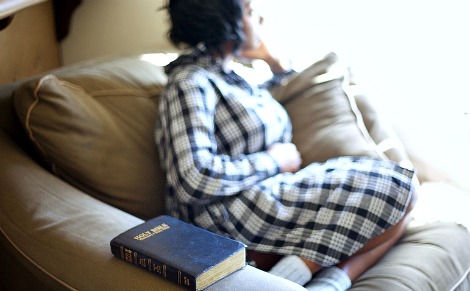 Pregnant woman sits by Bible