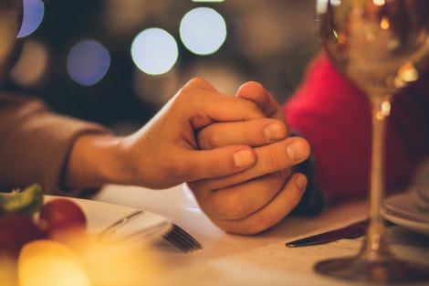 Adoptive couple praying at a Christmas dinner