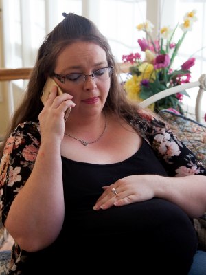 Pregnant woman talks on the phone with Christian adoptive parents she is interested in for her baby