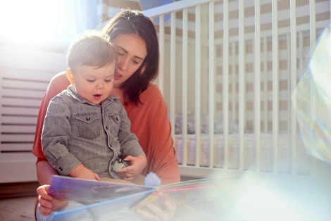 Mother reading a board book about adoption to her toddler