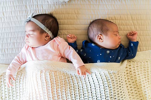 Fraternal girl/boy twin babies taking a nap together