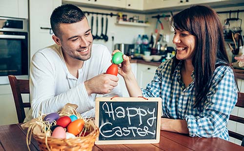 Young Christian couple breaking Easter eggs as they wait for the Amish Friendship Bread to rise