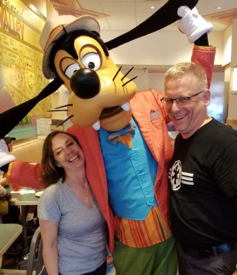 Dan and Michelle having fun posing by Goofy at Disney